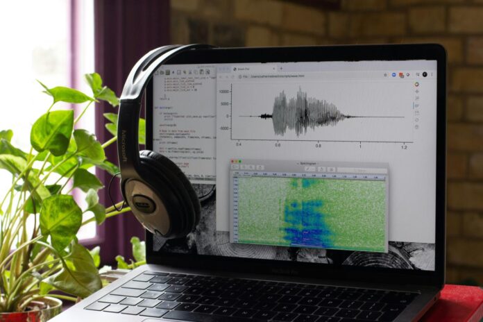 komputer laptop dengan headphone di atasnya